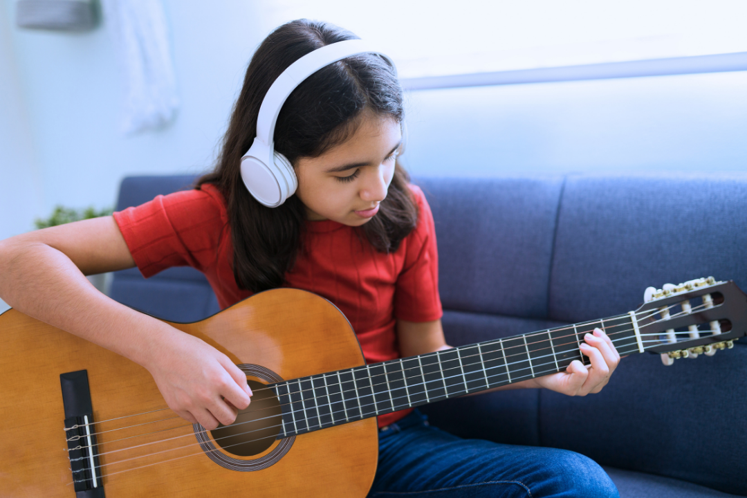 Criança tocando um instrumento. A importância da música no desenvolvimento infantil. Foto Reprodução: Freepik