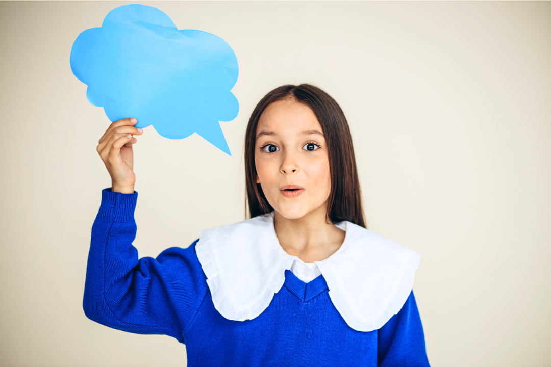 Menina segurando balão de fala azul. Inglês e Habilidades Sociais: Uma Conexão Poderosa. Foto Reprodução: Freepik.