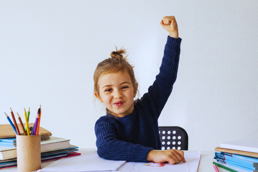 Menina animada estudando. Frases mágicas da Educação Positiva (em inglês!) para usar no dia a dia. Foto/Reprodução: Freepik.