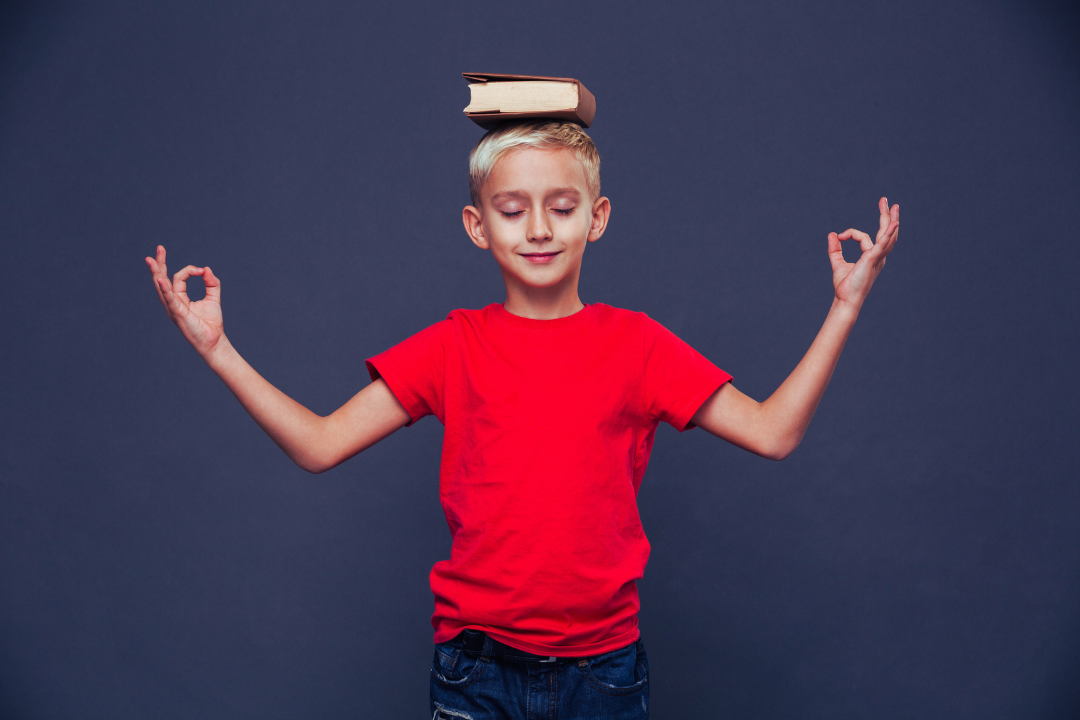Menino meditando com livros em sua cabeça. Usando a Educação Positiva para lidar com os erros no inglês. Foto/Reprodução: Freepik.