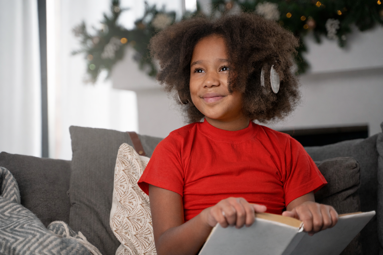 Menina feliz estudando com fones de ouvido. Como as crianças aprendem uma segunda língua naturalmente? Foto/Reprodução: Freepik.
