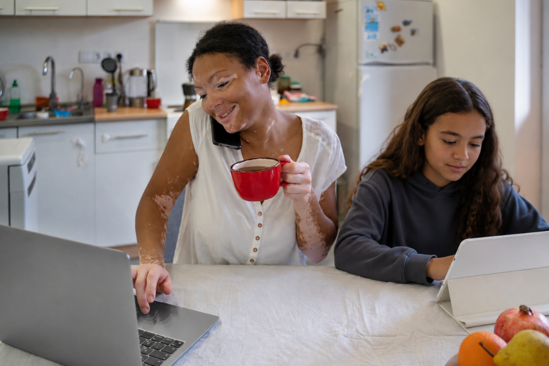 Mãe utilizando o notebook enquanto filha utiliza o tablet. Metas de inglês para o segundo semestre: como definir objetivos para crianças e adolescentes? Foto/Reprodução: Freepik e ChatGPT.
