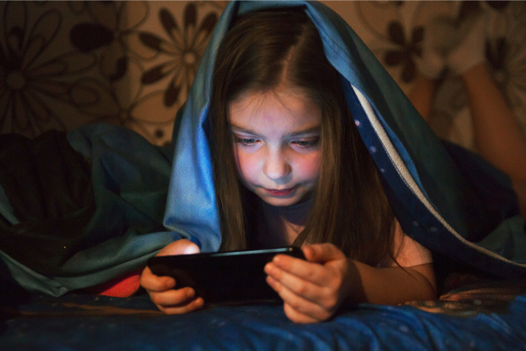 Menina navegando na internet pelo celular. Cyberbullying: como proteger nossas crianças? Foto/Reprodução: Freepik.