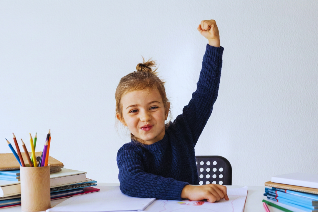 Menina animada estudando. Frases mágicas da Educação Positiva (em inglês!) para usar no dia a dia. Foto/Reprodução: Freepik.