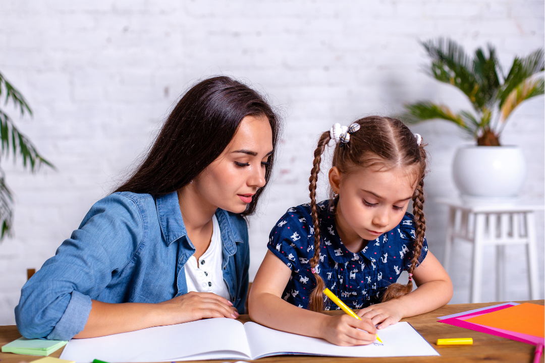 Mãe auxiliando filha em atividade. Progresso do seu filho no inglês: Como acompanhar? Foto/Reprodução; Freepik.