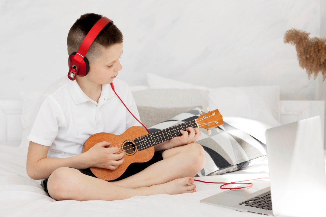 Menino tocando instrumento musical. Aulas de música no Kidsa: como elas funcionam? Foto/Reprodução: Freepik.