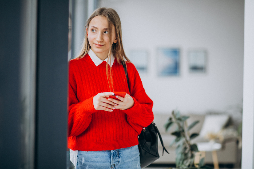 Menina olhando para um ponto fixo enquanto segura o celular. Inglês para o futuro: como adolescentes podem usar o idioma na carreira? Foto/Reprodução: Freepik.
