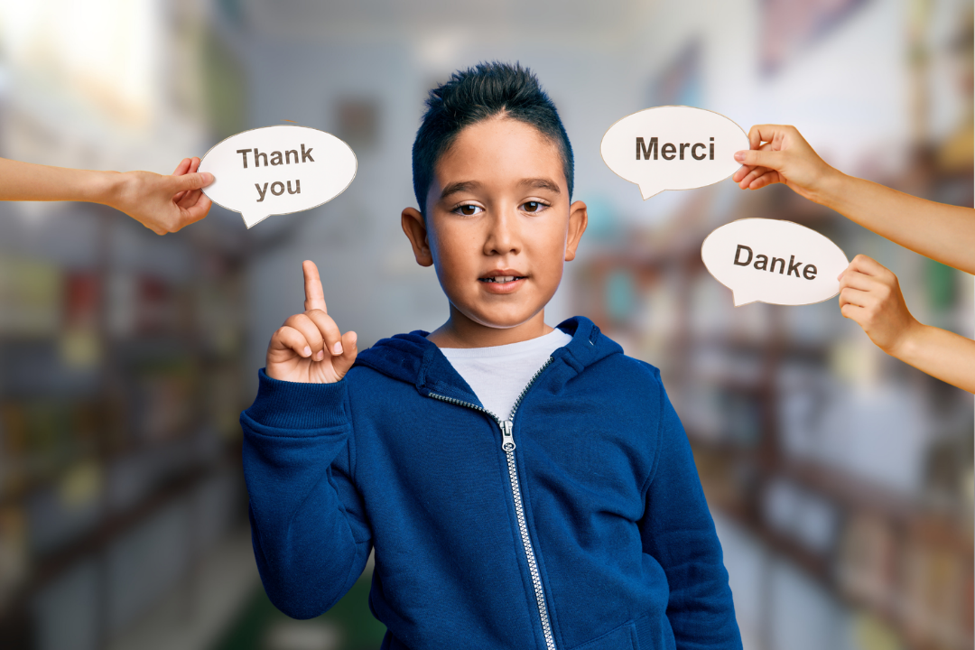Menino atento apontando para mãos com palavras em idiomas diferentes. Mitos e verdades sobre o bilinguismo infantil. Foto/Reprodução: Freepik.