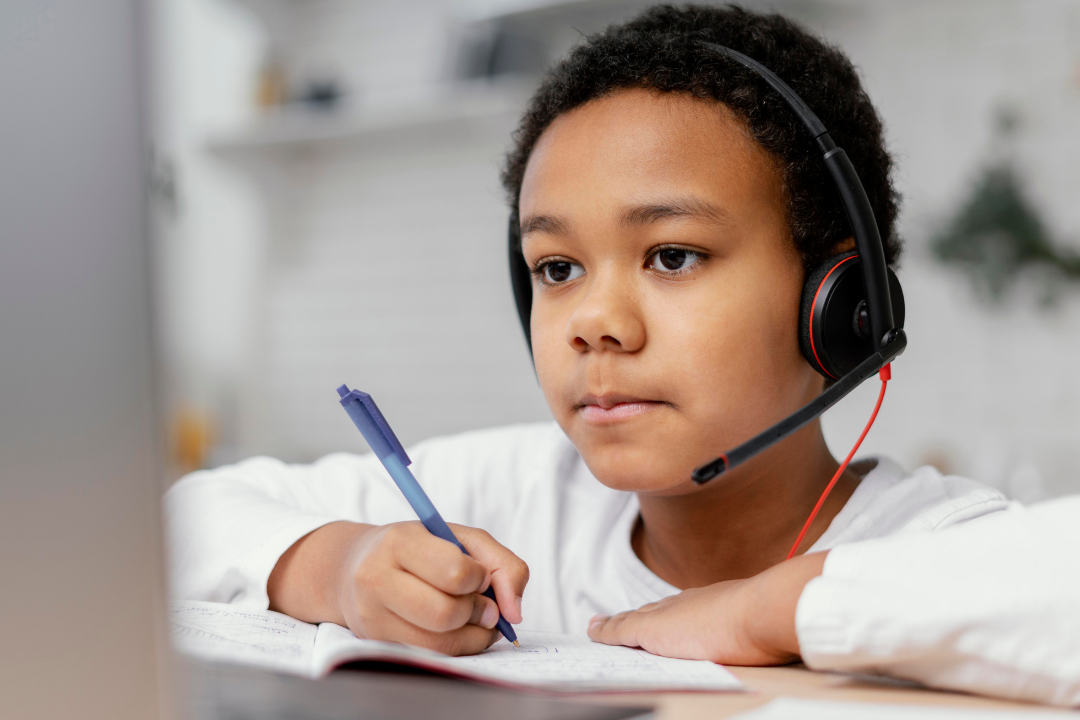Menino esudando pelo computador. Qual é a idade ideal para aprender inglês? Foto/Reprodução: Freepik.