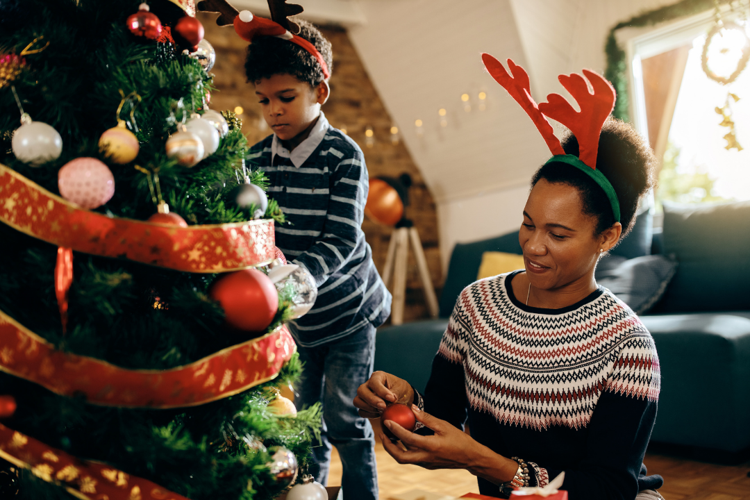 Mãe e filho enfeitando árvore de natal. Natal pelo mundo: como é comemorado em diferentes países? Foto/Reprodução: Freepik.