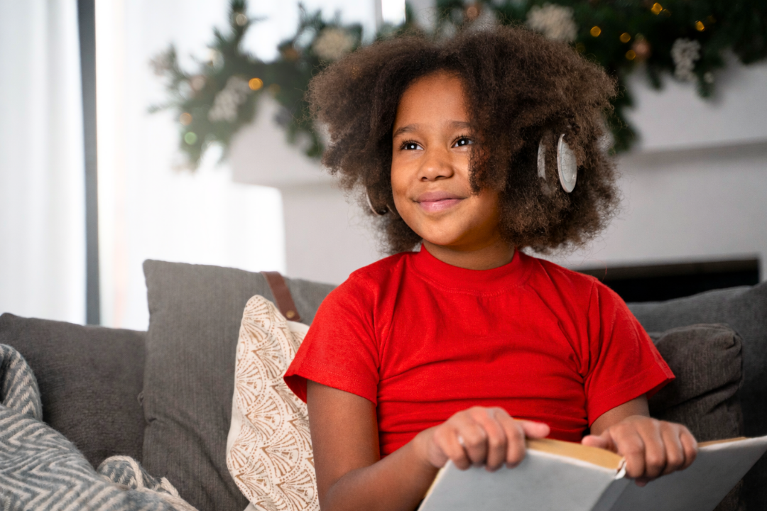 Menina feliz estudando com fones de ouvido. Como as crianças aprendem uma segunda língua naturalmente? Foto/Reprodução: Freepik.