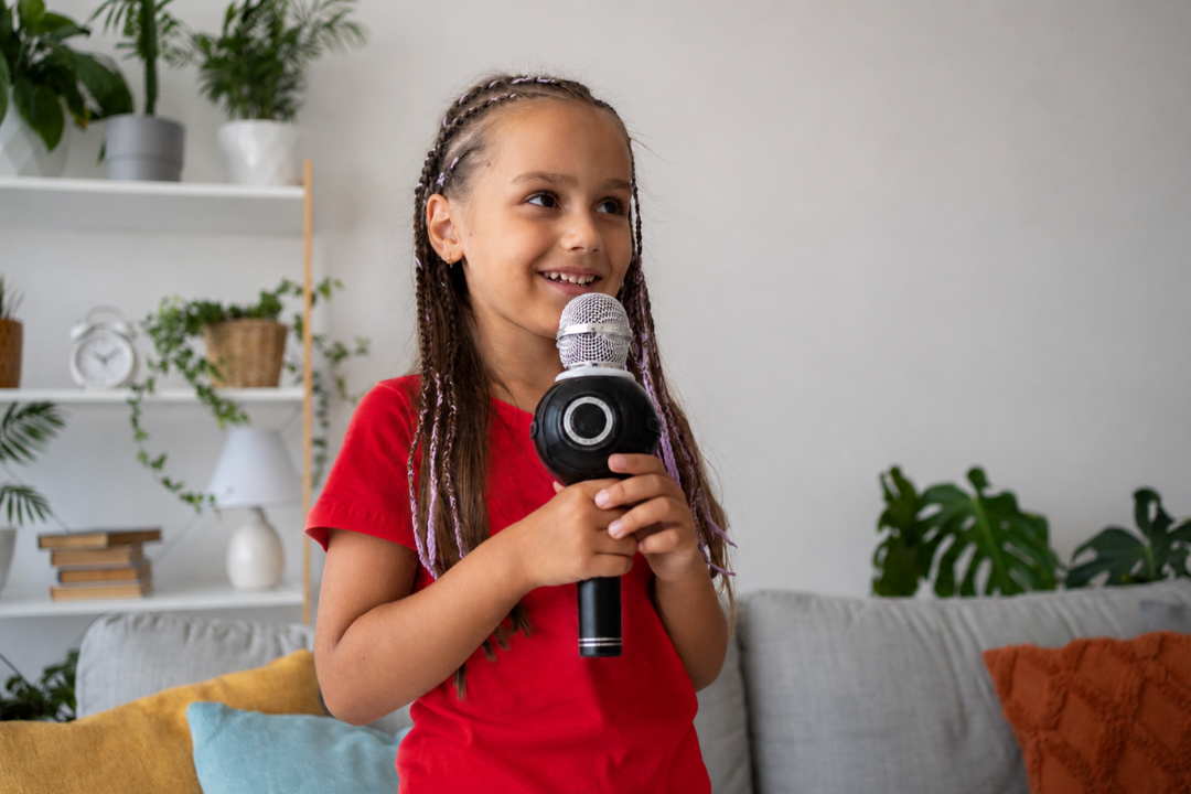 Menina feliz cantando em sua casa. Músicas em inglês ajudam mais no aprendizado do idioma? Foto/Reprodução: Freepik + GPT.