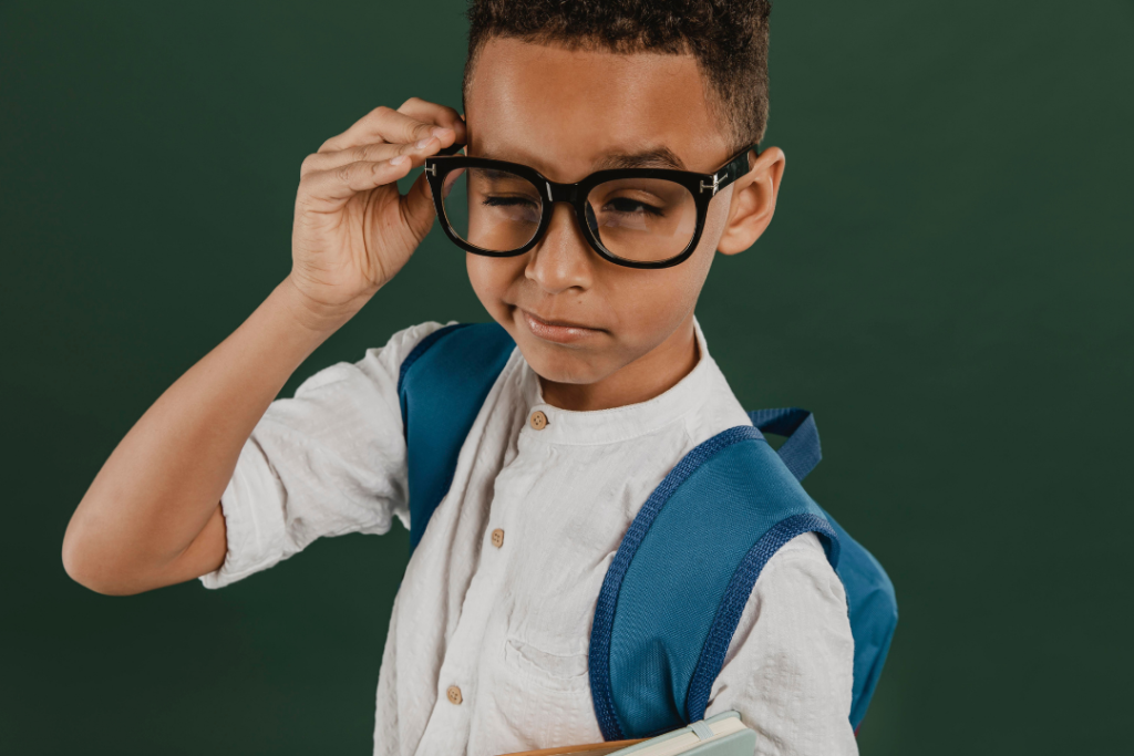Menino segurando o óculos e pensativo. Repetição no aprendizado de inglês: Quais são os benefícios? Foto/Reprodução: Freepik.