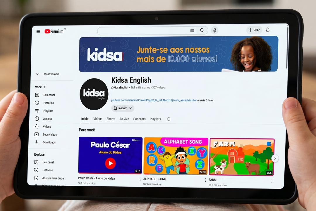 Criança segurando tablet no canal do Youtube do Kidsa. Kidsa no Youtube: aprenda inglês com nossas músicas! Foto/Reprodução: Gemini.